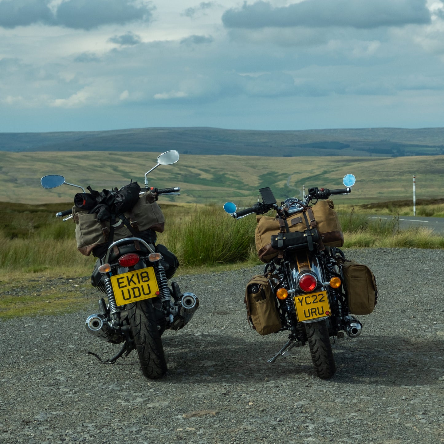 Two modern classic motorcycles with soft canvas touring luggage