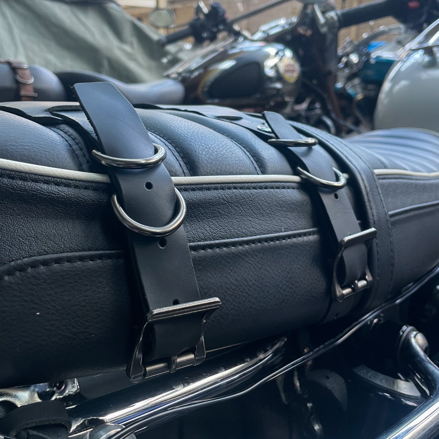 Close-up of motorcycle saddlebag mounting leather straps in black.
